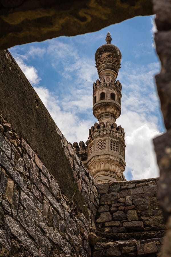 Minaret, Framed. A Qutb Shahi minaret glimpsed through a break in the old stone walls, Hyderabad.